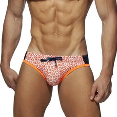 a sexy gay man in Orange Black DESMIIT Men's Leopard Print Bowtie Swim Briefs - pridevoyageshop.com - gay men’s underwear and swimwear