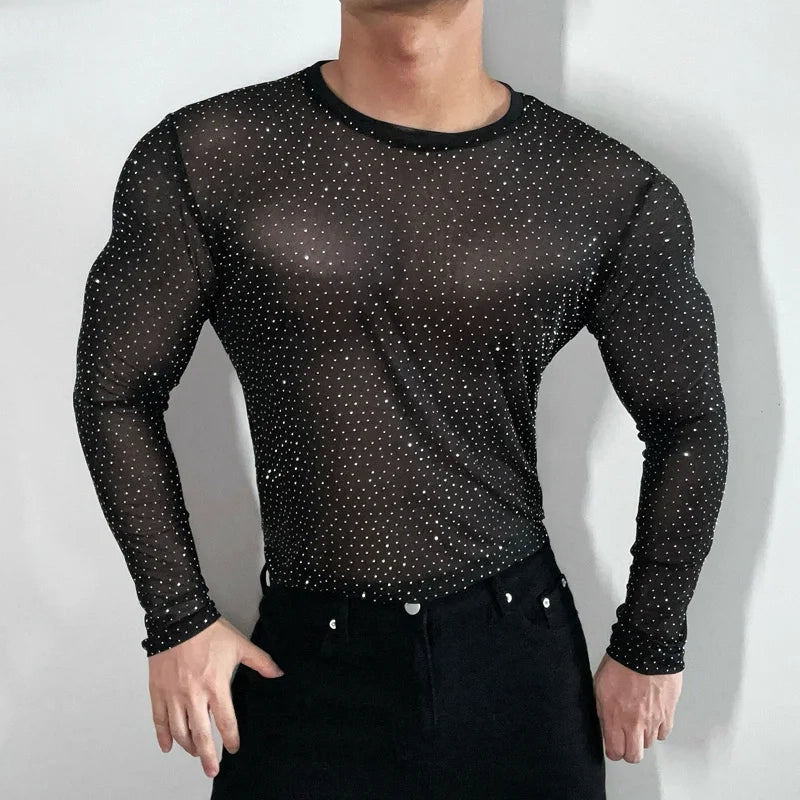 Twinkle Twunk Mesh Long Sleeve Black color sheer sparkle mesh long sleeve top worn by a muscular gay man posing in studio lighting pridevoyageshopcom gay mens gym tank tops mesh tank tops clubwear fashion tops and activewear