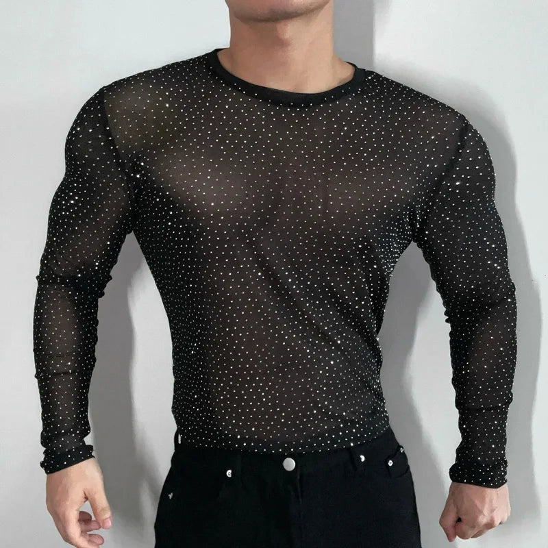 Twinkle Twunk Mesh Long Sleeve Black color sheer sparkle mesh long sleeve top worn by a muscular gay man posing in studio lighting pridevoyageshopcom gay mens gym tank tops mesh tank tops clubwear fashion tops and activewear