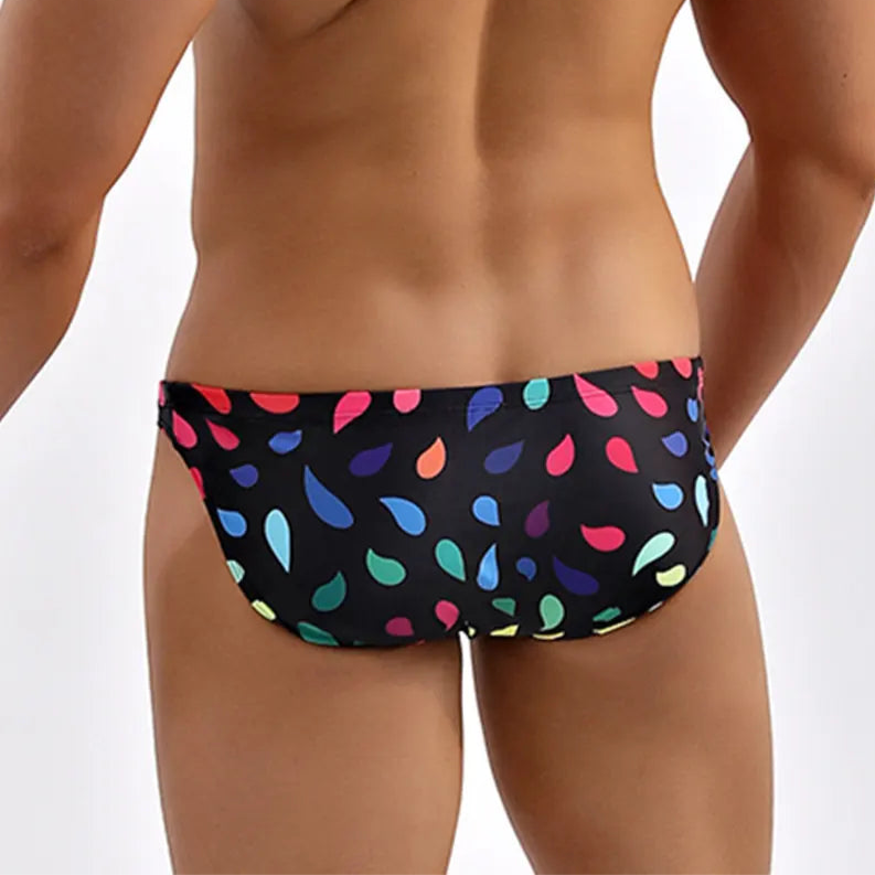 a hot man in Men’s Drippin’ Pride Swim Briefs - pridevoyageshop.com - gay men’s sexy swim briefs, trunks, board shorts, and bikinis