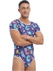 a sexy man in Gaylaxy Dinos Daddy’s Boy Printed Onesie, playful fit, body-hugging cartoon print, showing cheeky youthful vibe – pridevoyageshop.com – gay men’s harness, lingerie and fetish wear