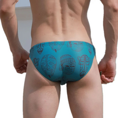 a sexy man in Teal Totem Men’s Poolside Rites Swim Briefs - pridevoyageshop.com - gay men’s sexy swim briefs, trunks, board shorts, and bikinis