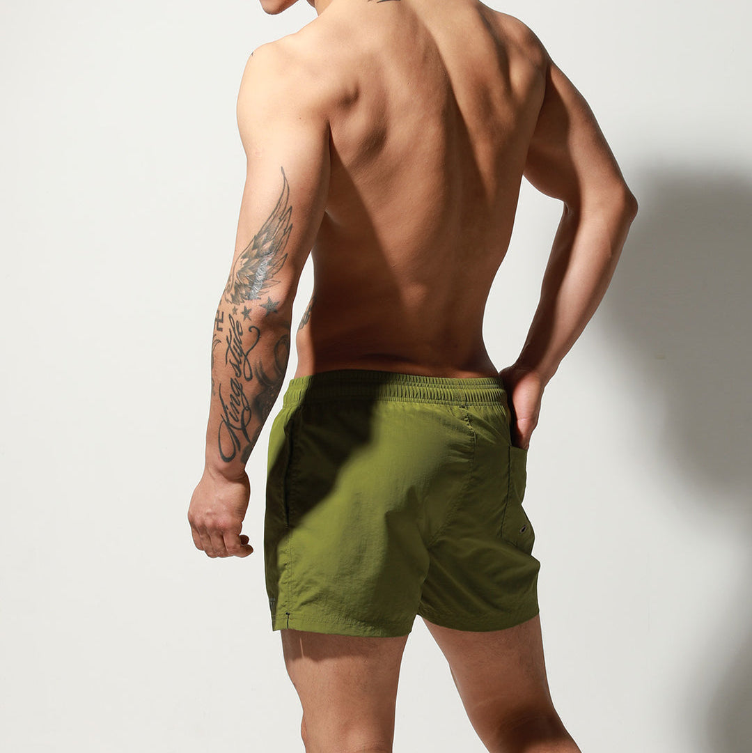 a sexy man in army green Desmiit Men’s Circuit Signal Swim Short – pridevoyageshop.com – gay men’s sexy swim briefs, trunks, board shorts, and bikinis