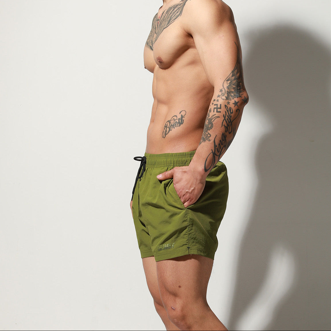 a sexy man in army green Desmiit Men’s Circuit Signal Swim Short – pridevoyageshop.com – gay men’s sexy swim briefs, trunks, board shorts, and bikinis
