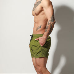 a sexy man in army green Desmiit Men’s Circuit Signal Swim Short – pridevoyageshop.com – gay men’s sexy swim briefs, trunks, board shorts, and bikinis