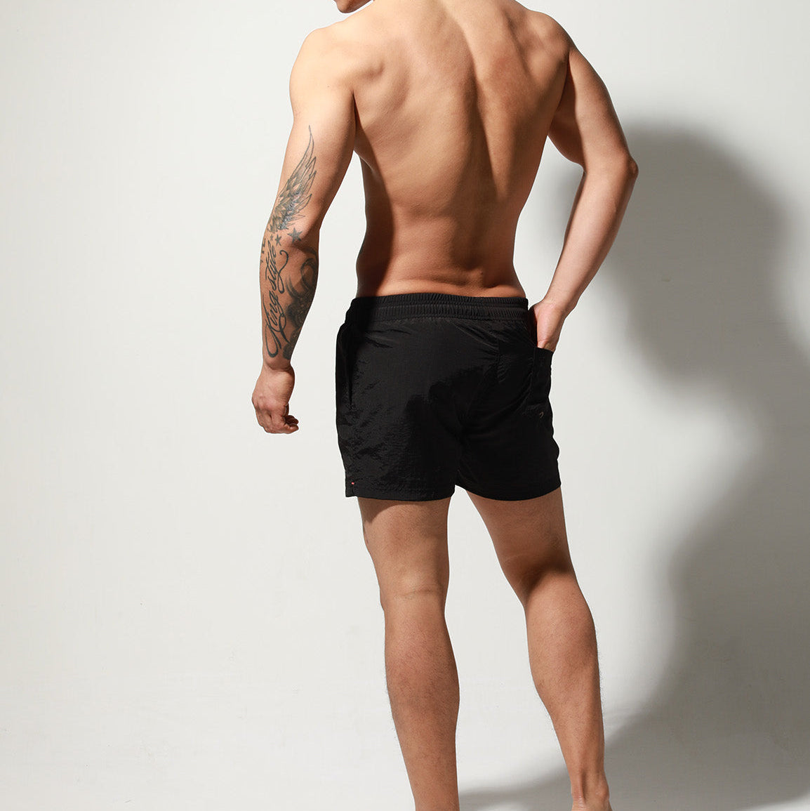 a sexy man in black Desmiit Men’s Circuit Signal Swim Short – pridevoyageshop.com – gay men’s sexy swim briefs, trunks, board shorts, and bikinis