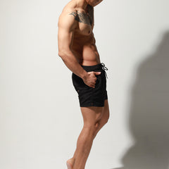 a sexy man in black Desmiit Men’s Circuit Signal Swim Short – pridevoyageshop.com – gay men’s sexy swim briefs, trunks, board shorts, and bikinis