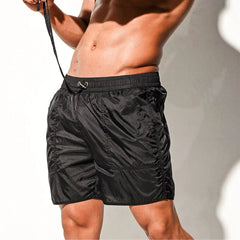 a sexy man in black Men’s Cellblock Sheen Swim Short – pridevoyageshop.com – gay men’s sexy swim briefs, trunks, board shorts, and bikinis