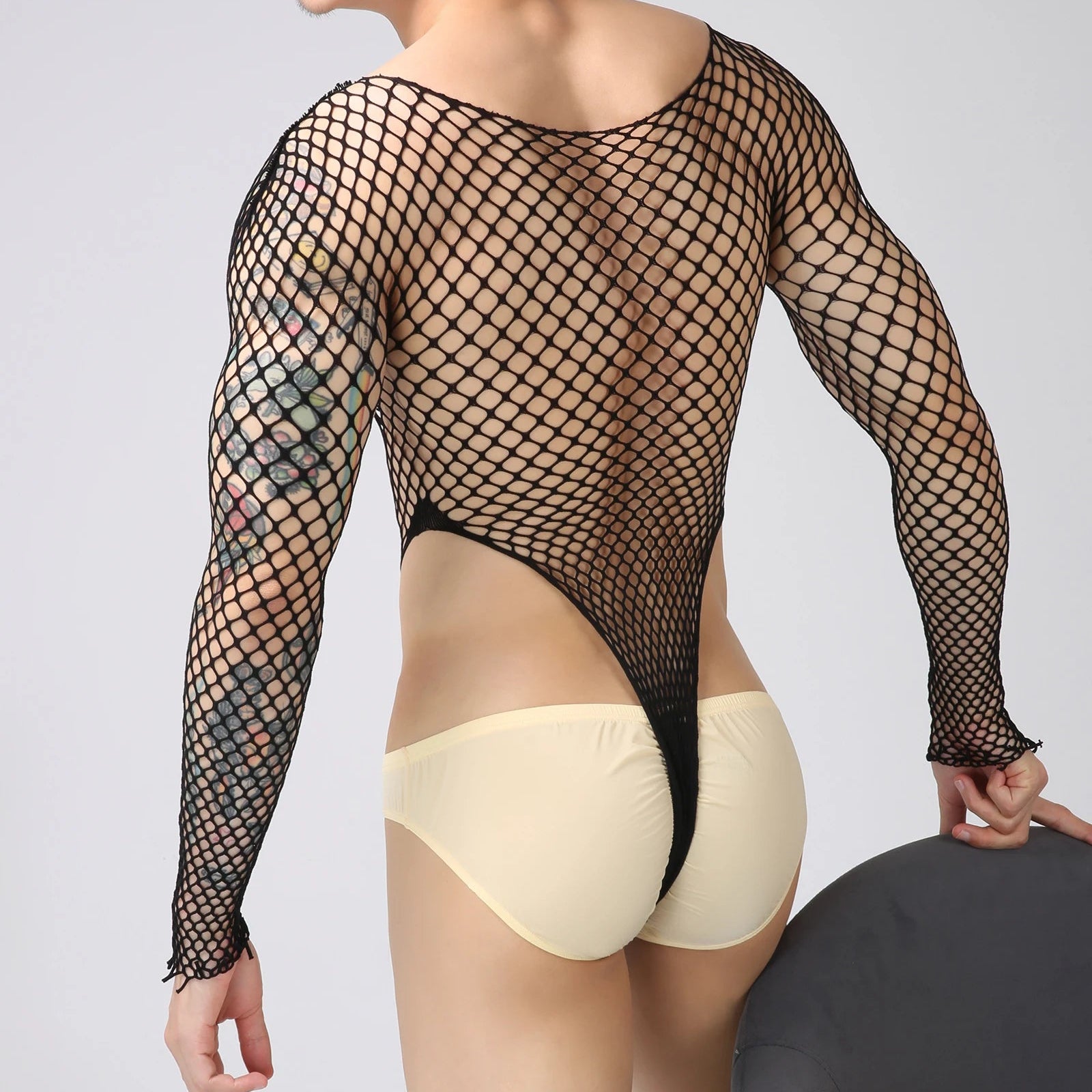 a sexy man in black Men’s Ensnare Fishnet Thong Bodysuit – pridevoyageshop.com – gay men’s harness, lingerie and fetish wear