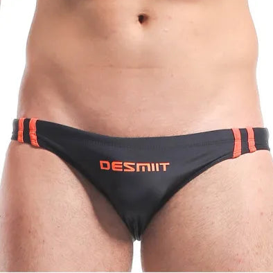 a sexy man in black Men’s Fast & Curious Skinny Swim Briefs - pridevoyageshop.com - gay men’s sexy swim briefs, trunks, board shorts, and bikinis