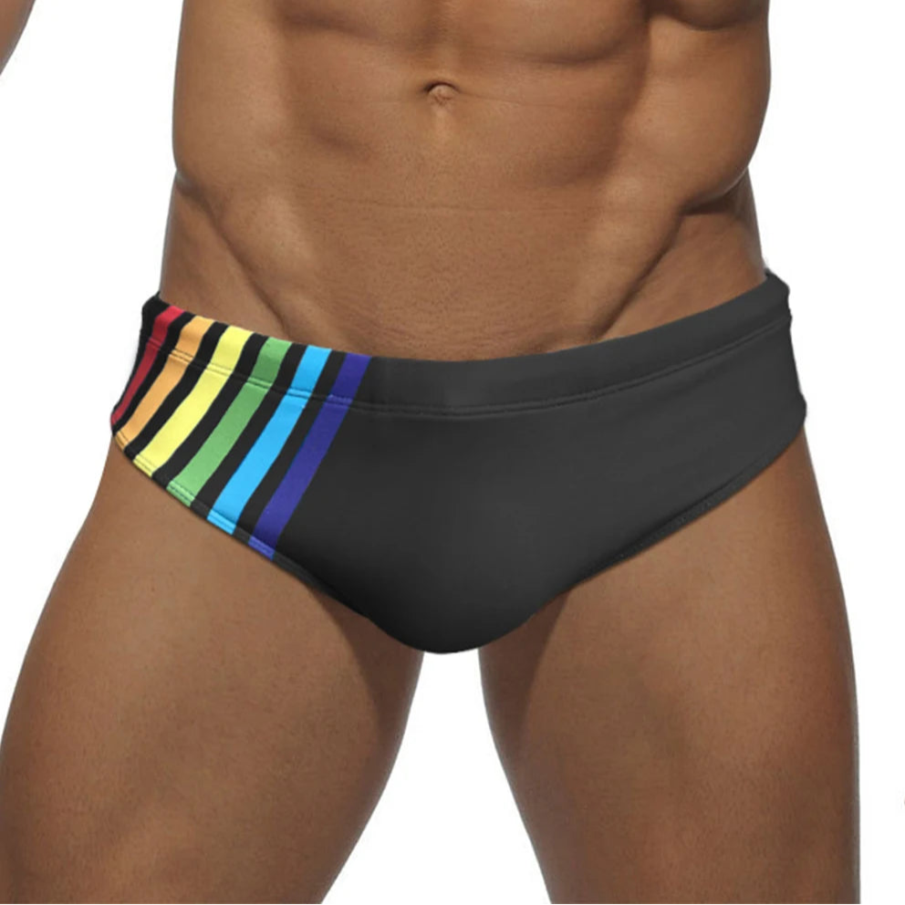 a sexy man in black Men’s Pride Streak Bikini Swim Briefs - pridevoyageshop.com - gay men’s sexy swim briefs, trunks, board shorts, and bikinis