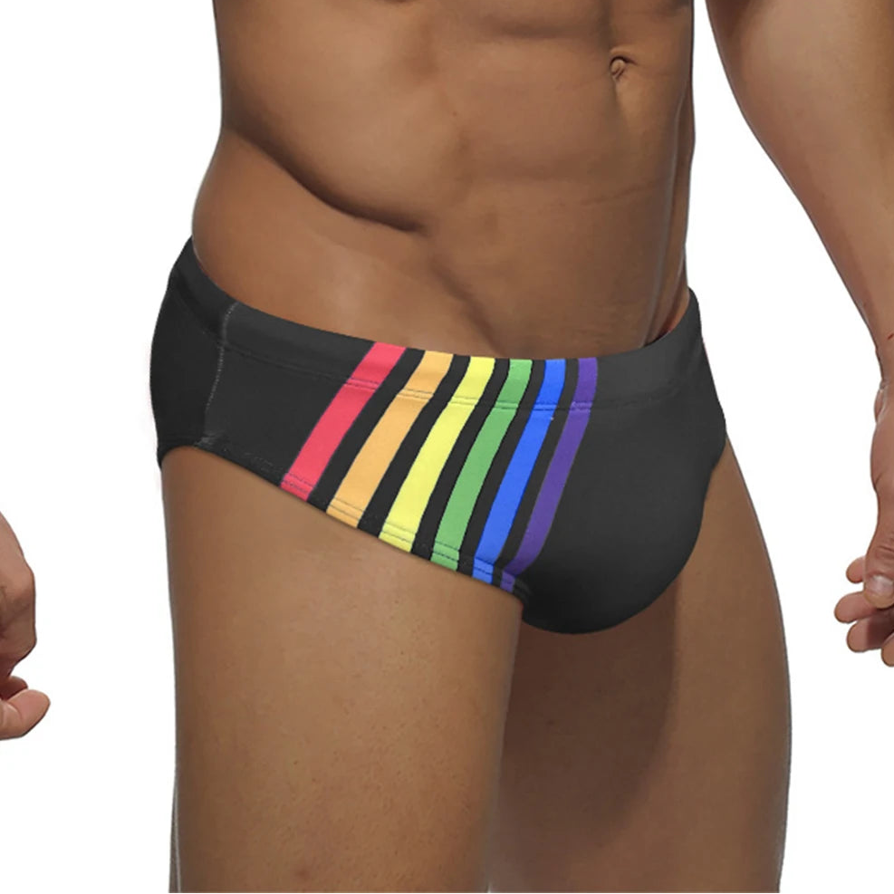 a sexy man in black Men’s Pride Streak Bikini Swim Briefs - pridevoyageshop.com - gay men’s sexy swim briefs, trunks, board shorts, and bikinis