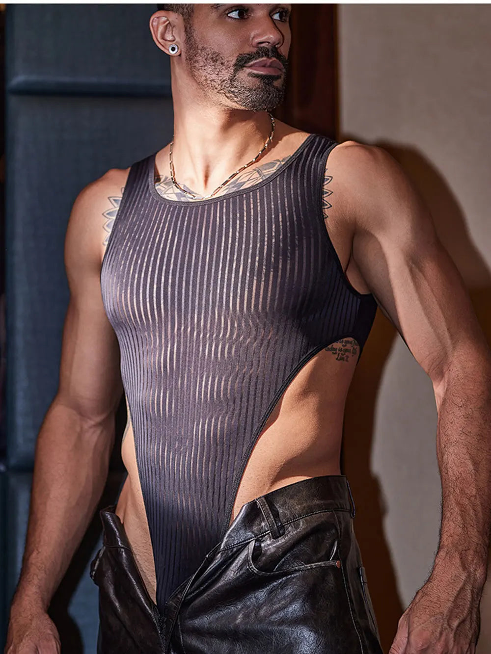 a sexy man in black Vertigo Stripe Sheer Bodysuit – pridevoyageshop.com – gay men’s harness, lingerie and fetish wear