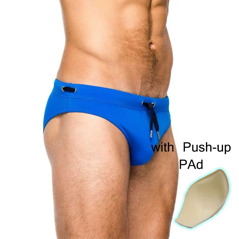 a sexy man in blue Men’s Beach Brat Swim Briefs with pad - pridevoyageshop.com - gay men’s sexy swim briefs, trunks, board shorts, and bikinis