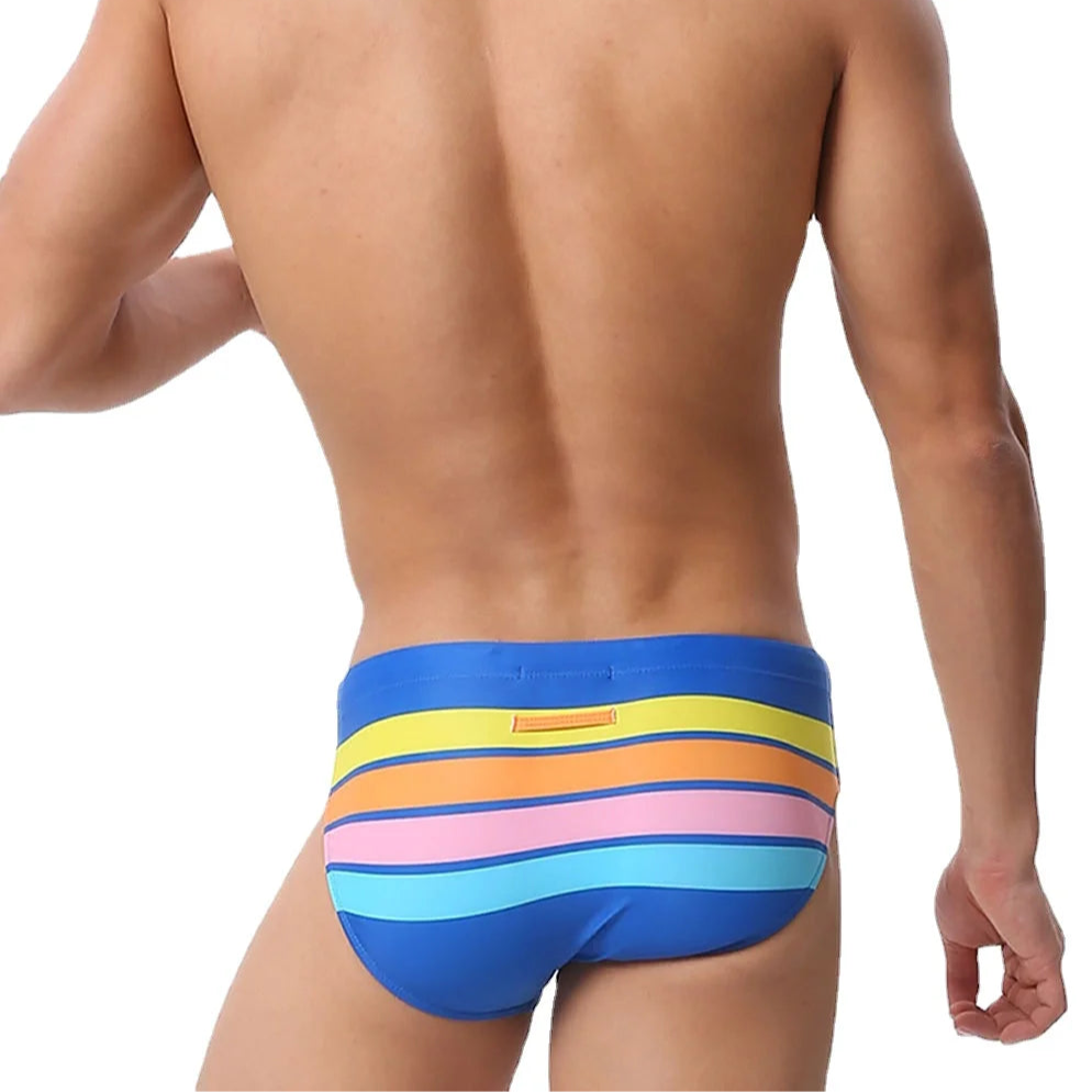 a sexy man in blue Men’s Bottom Line Stripe Swim Briefs - pridevoyageshop.com - gay men’s sexy swim briefs, trunks, board shorts, and bikinis