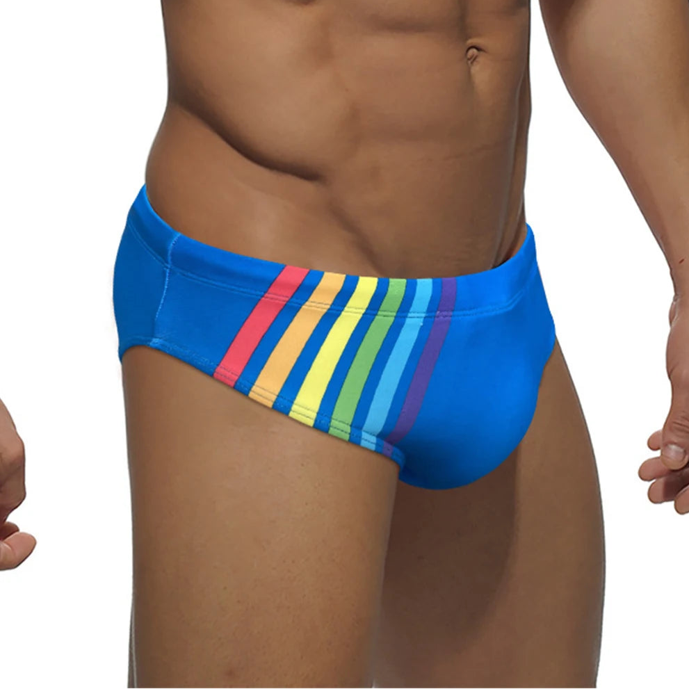 a sexy man in blue Men’s Pride Streak Bikini Swim Briefs - pridevoyageshop.com - gay men’s sexy swim briefs, trunks, board shorts, and bikinis