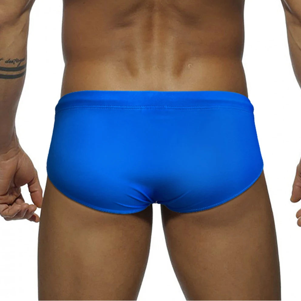 a sexy man in blue Men’s Pride Streak Bikini Swim Briefs - pridevoyageshop.com - gay men’s sexy swim briefs, trunks, board shorts, and bikinis
