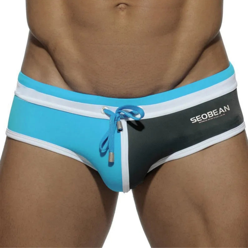 a sexy man in blue and dark gray Men’s Split Decision Bulge Swim Briefs - pridevoyageshop.com - gay men’s sexy swim briefs, trunks, board shorts, and bikinis