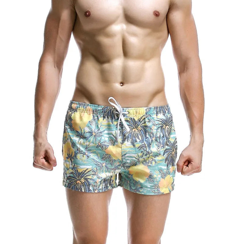 a sexy man in cyan blue Men’s Tap-Ready Tides Swim Beach Surf Shorts – pridevoyageshop.com – gay men’s sexy swim briefs, trunks, board shorts, and bikinis