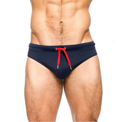 a sexy man in dark blue Men’s Beach Brat Swim Briefs - pridevoyageshop.com - gay men’s sexy swim briefs, trunks, board shorts, and bikinis