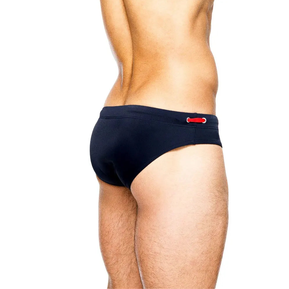 a sexy man in dark blue Men’s Beach Brat Swim Briefs - pridevoyageshop.com - gay men’s sexy swim briefs, trunks, board shorts, and bikinis