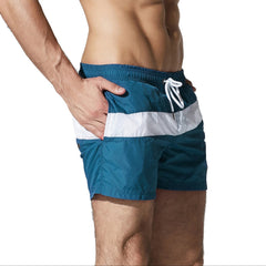 a sexy man in dark blue Men’s Block Party Volley Swim Short – pridevoyageshop.com – gay men’s sexy swim briefs, trunks, board shorts, and bikinis