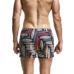 a sexy man in dark blue Men’s Tap-Ready Tides Swim Beach Surf Shorts – pridevoyageshop.com – gay men’s sexy swim briefs, trunks, board shorts, and bikinis