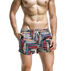 a sexy man in dark blue Men’s Tap-Ready Tides Swim Beach Surf Shorts – pridevoyageshop.com – gay men’s sexy swim briefs, trunks, board shorts, and bikinis