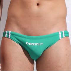 a sexy man in green Men’s Fast & Curious Skinny Swim Briefs - pridevoyageshop.com - gay men’s sexy swim briefs, trunks, board shorts, and bikinis