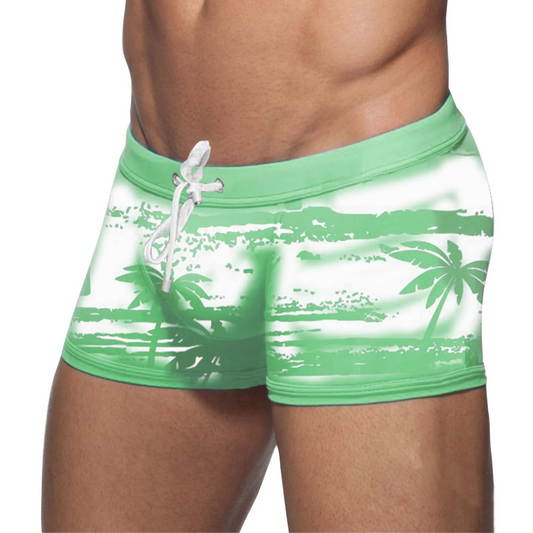a sexy man in green Men’s Holiday Hung Swim Trunks- pridevoyageshop.com - gay men’s sexy swim briefs, trunks, board shorts, and bikinis
