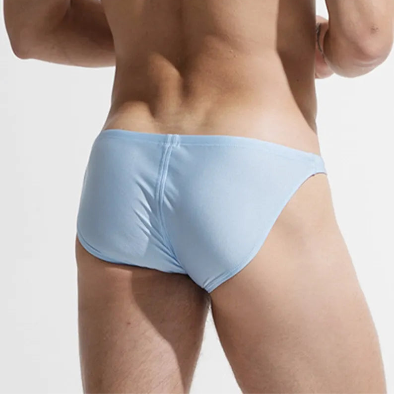 a sexy man in light blue Desmiit Men’s Below Sea Level Bikini Swim Briefs - pridevoyageshop.com - gay men’s sexy swim briefs, trunks, board shorts, and bikinis