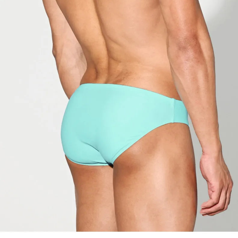 a sexy man in light blue Desmiit Men’s Brunch-Ready Bikini Swim Briefs - pridevoyageshop.com - gay men’s sexy swim briefs, trunks, board shorts, and bikinis
