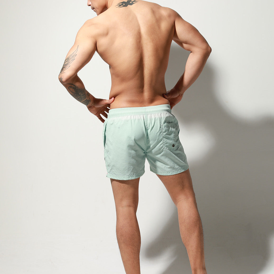 a sexy man in light blue Desmiit Men’s Circuit Signal Swim Short – pridevoyageshop.com – gay men’s sexy swim briefs, trunks, board shorts, and bikinis