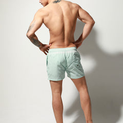 a sexy man in light blue Desmiit Men’s Circuit Signal Swim Short – pridevoyageshop.com – gay men’s sexy swim briefs, trunks, board shorts, and bikinis
