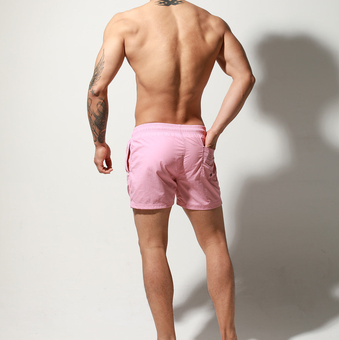 a sexy man in light pink Desmiit Men’s Circuit Signal Swim Short – pridevoyageshop.com – gay men’s sexy swim briefs, trunks, board shorts, and bikinis
