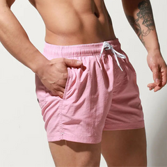 a sexy man in light pink Desmiit Men’s Circuit Signal Swim Short – pridevoyageshop.com – gay men’s sexy swim briefs, trunks, board shorts, and bikinis