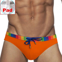 a sexy man in orange Men’s Pride Patrol Rainbow Band Swim Briefs with pad - pridevoyageshop.com - gay men’s sexy swim briefs, trunks, board shorts, and bikinis