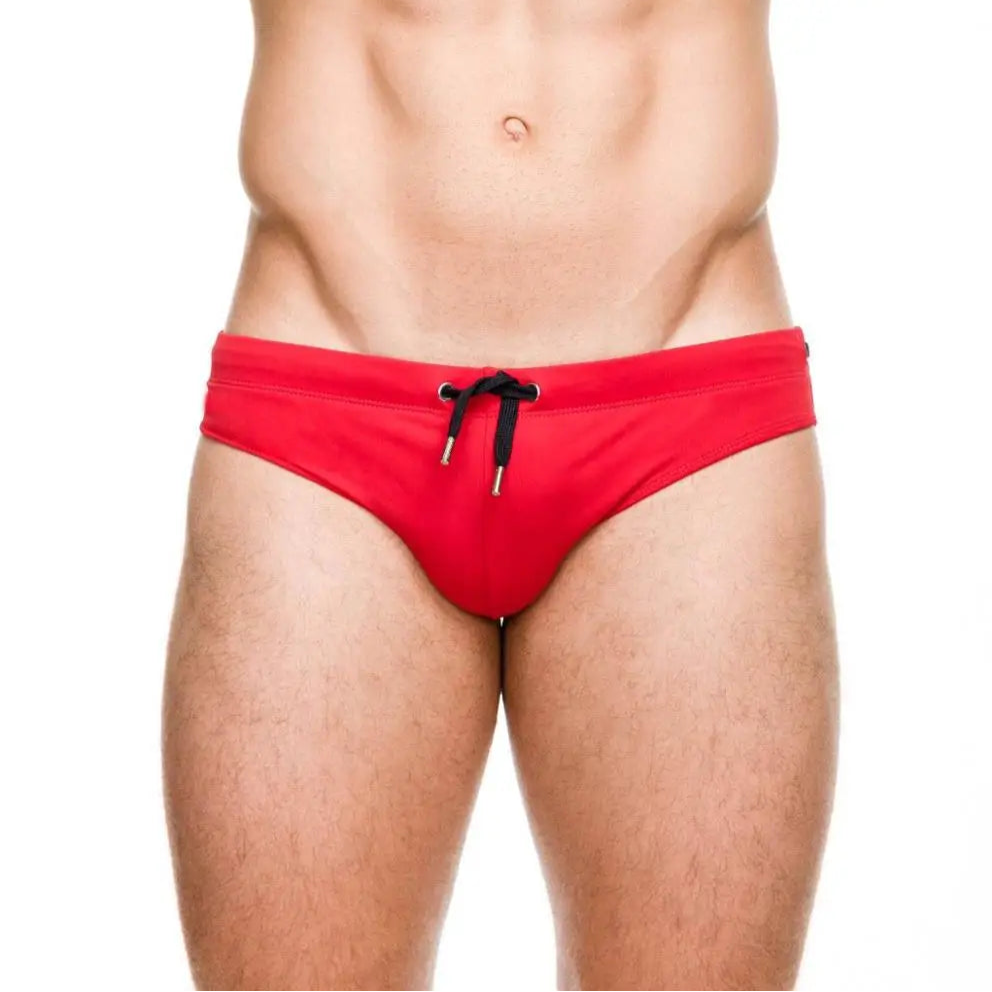 a sexy man in red Men’s Beach Brat Swim Briefs - pridevoyageshop.com - gay men’s sexy swim briefs, trunks, board shorts, and bikinis