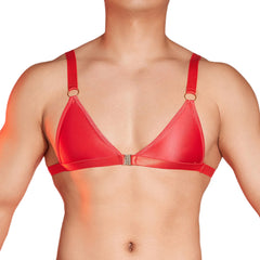 a sexy man in red faux-leather bralette with front clasp, shiny chest panel and sultry fetish energy, bold gay lingerie look – pridevoyageshop.com – gay men’s harness, lingerie and fetish wear