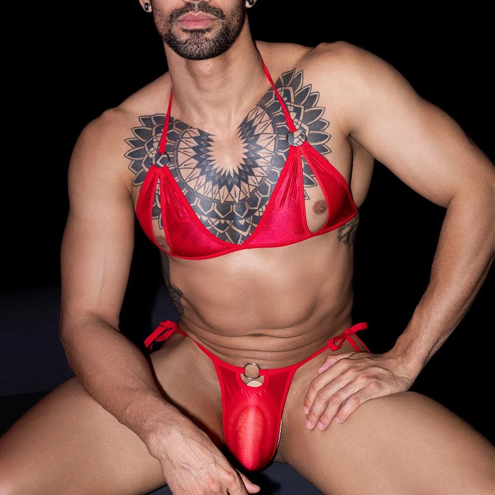 a sexy man in red satin O-ring lingerie set, sheer bulge pouch and silky straps, seductive boy-toy gay lingerie look – pridevoyageshop.com – gay men’s harness, lingerie and fetish wear