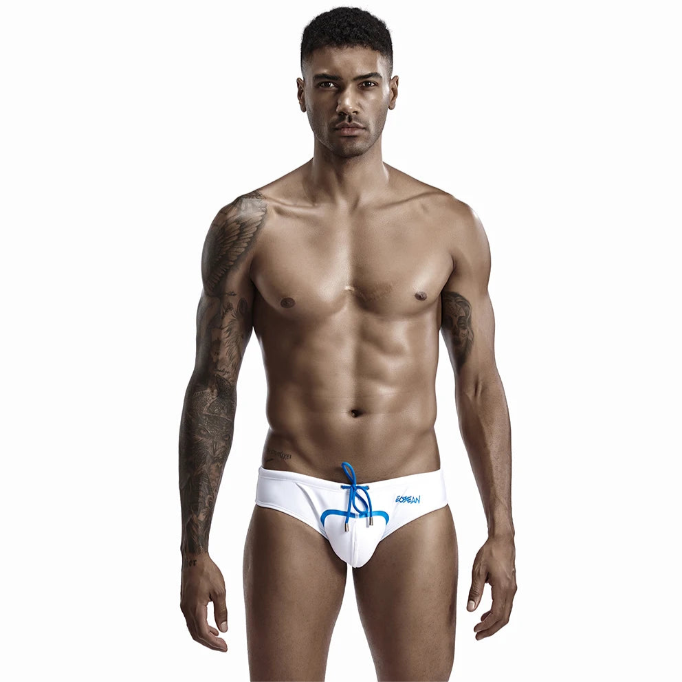 a sexy man in white Men’s Bold Bulge Wave Swim Briefs - pridevoyageshop.com - gay men’s sexy swim briefs, trunks, board shorts, and bikinis