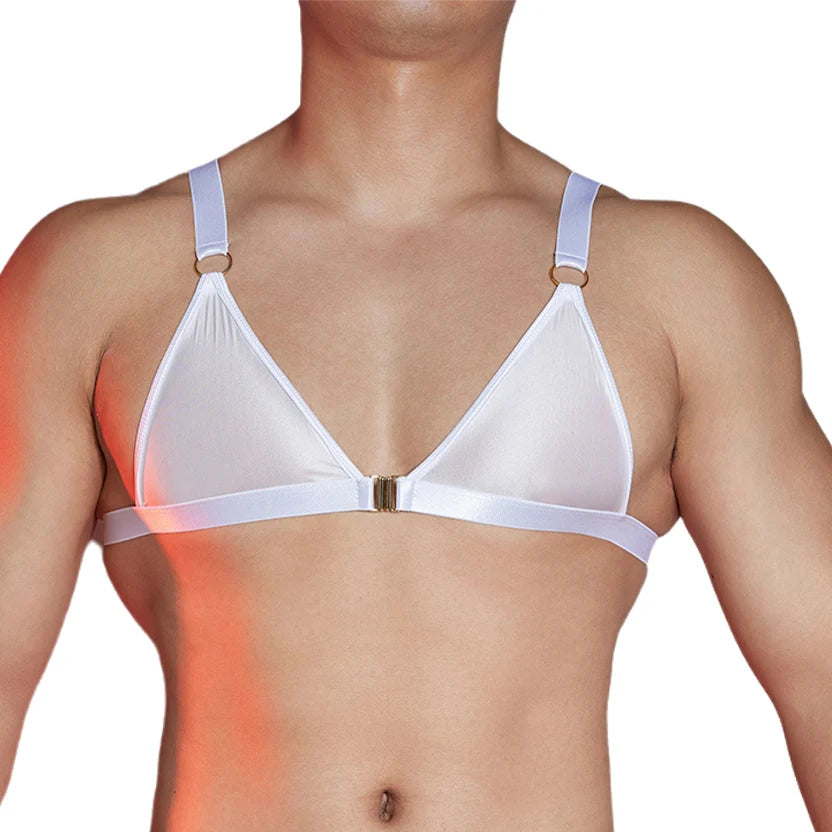 a sexy man in white faux-leather front-clasp bralette, glossy fetish chest cut and clean teasing lines – pridevoyageshop.com – gay men’s harness, lingerie and fetish wear
