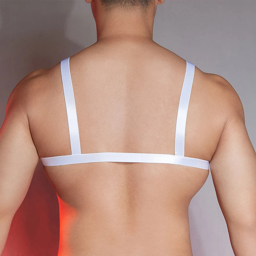 a sexy man in white faux-leather front-clasp bralette, glossy fetish chest cut and clean teasing lines – pridevoyageshop.com – gay men’s harness, lingerie and fetish wear
