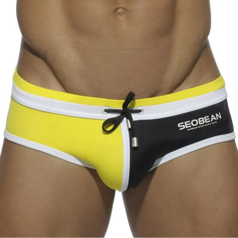 a sexy man in yellow and black Men’s Split Decision Bulge Swim Briefs - pridevoyageshop.com - gay men’s sexy swim briefs, trunks, board shorts, and bikinis
