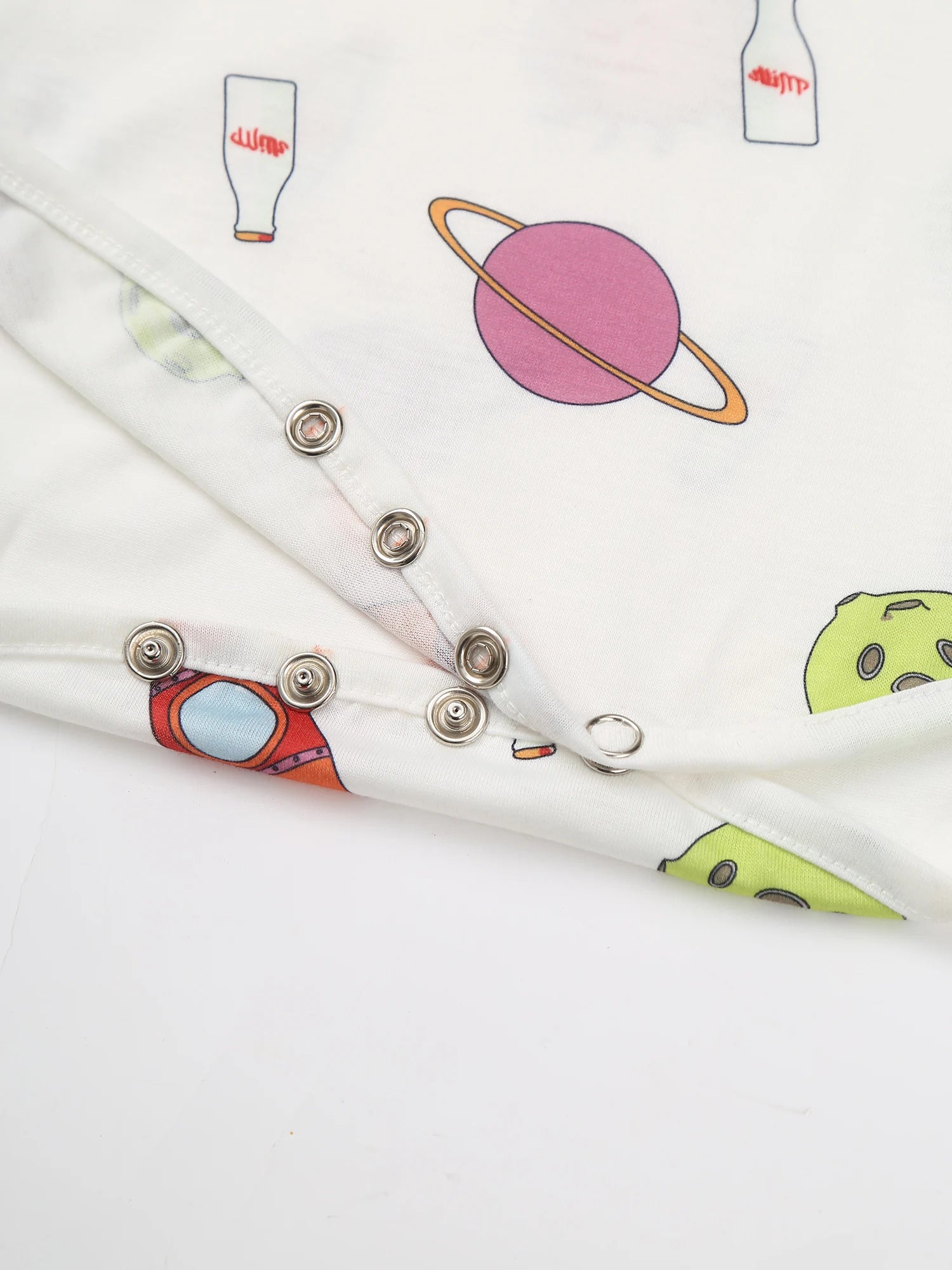 details of Daddy’s Boy Printed Onesie flat lay, cosmic cartoon print, stretchy cute fabric, playful twink style – pridevoyageshop.com – gay men’s harness, lingerie and fetish wear